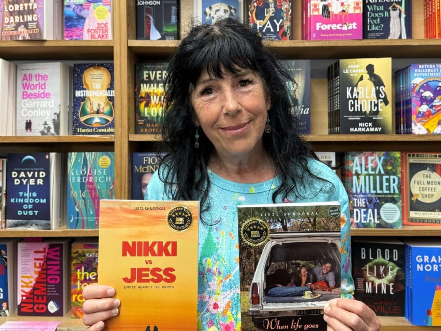 Liezl Shnookal with her two coming-of-age novels Liezl Shnookal, Australian author, holding her two novels, Off Track and Nikki vs Jess, sharing the story behind their creation.