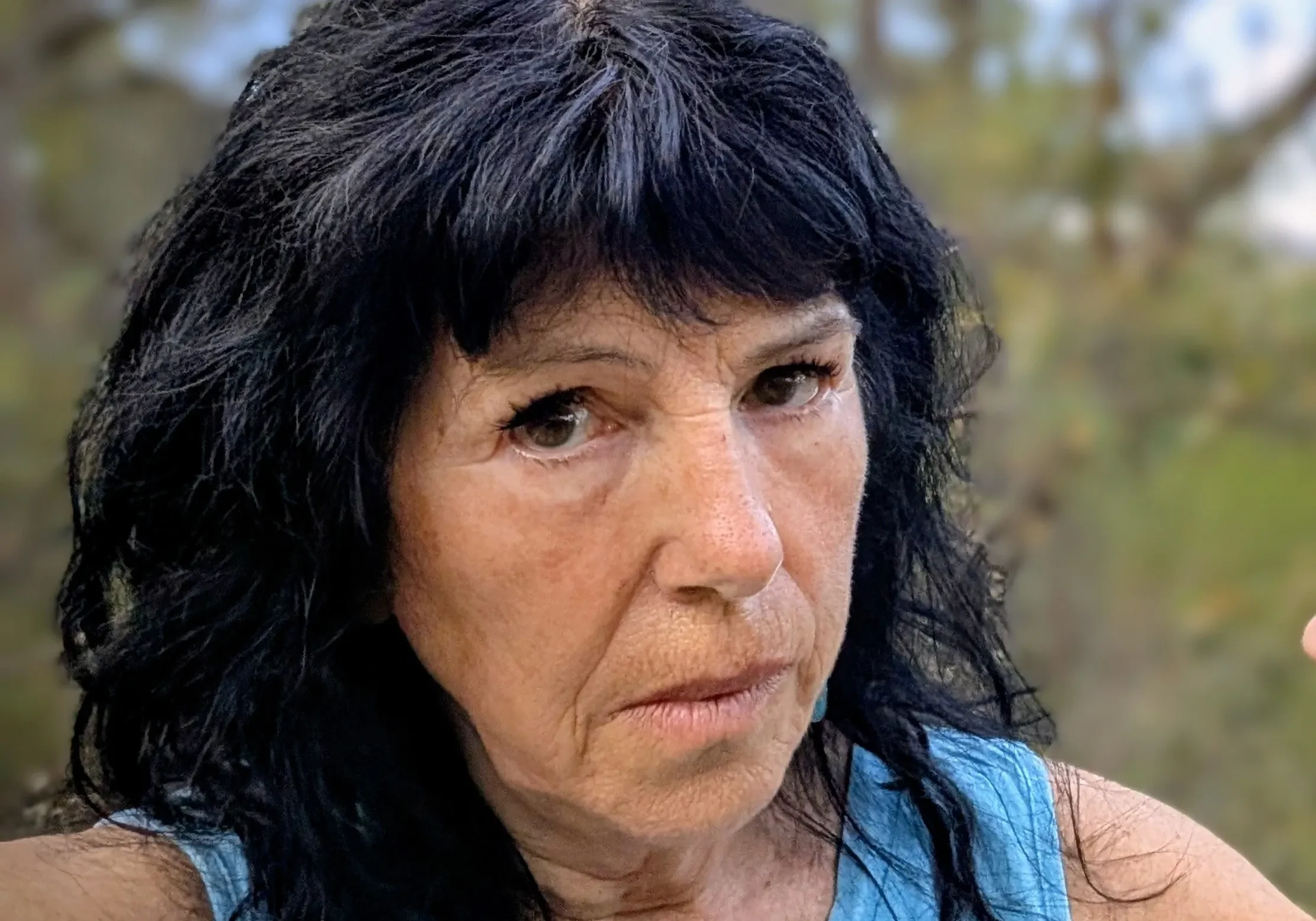 Close-up of person with dark hair, blue top