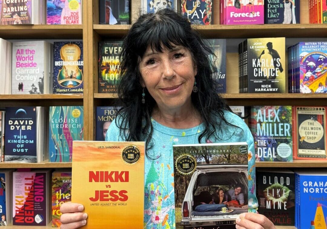 Award-winning author Liezl Shnookal proudly holding up her coming-of-age novels, Nikki vs Jess and Off Track.