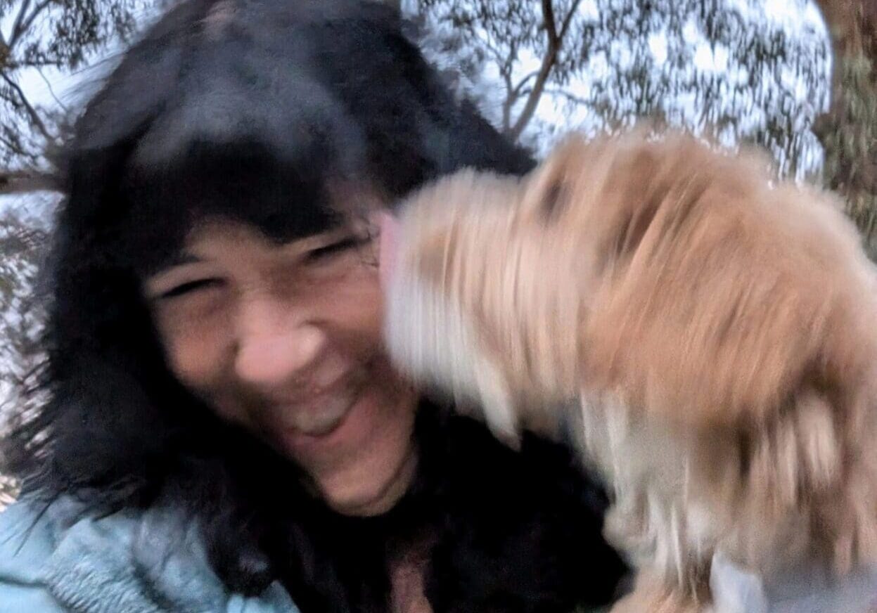 A woman and her dog are smiling for the camera.