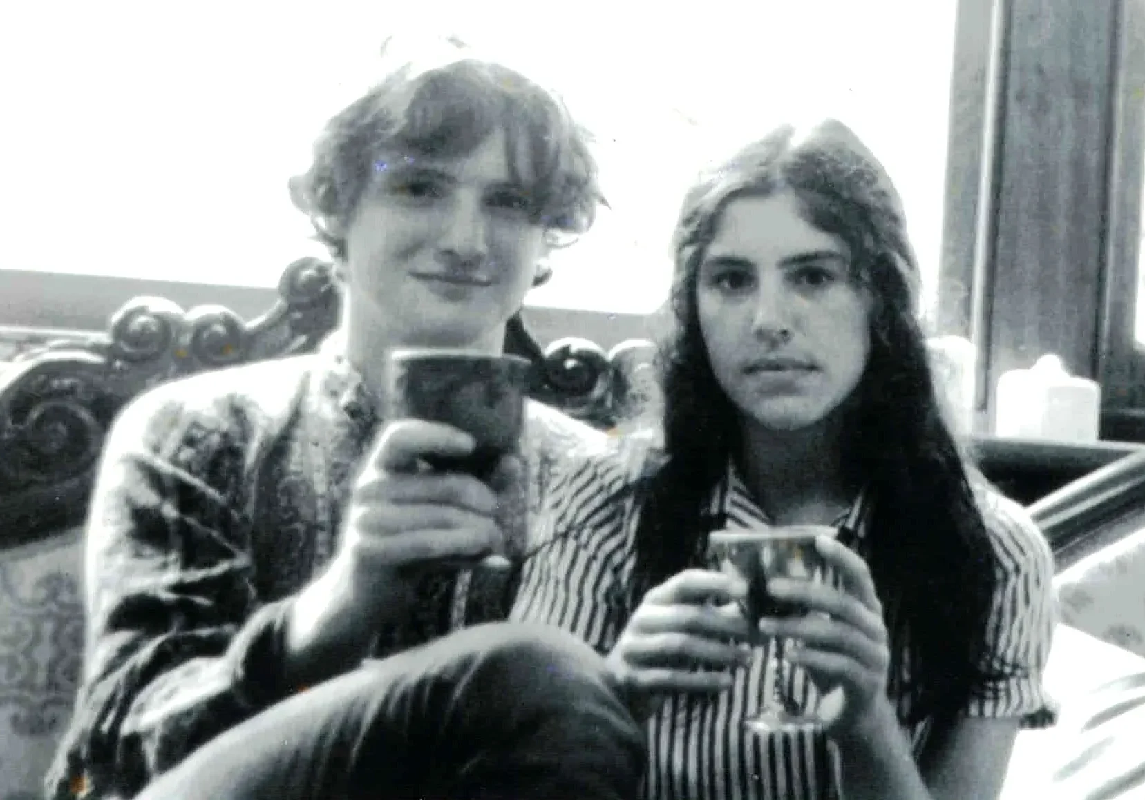 Two people holding glasses in black-and-white